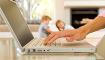 Hands of woman typing on laptop computer